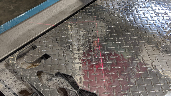 Mark Obannon, un idraulico di Nantucket, sta utilizzando il suo nuovo tavolo da taglio al plasma CNC Swift-Cut Pro per ritagliare una forma da una lamiera
