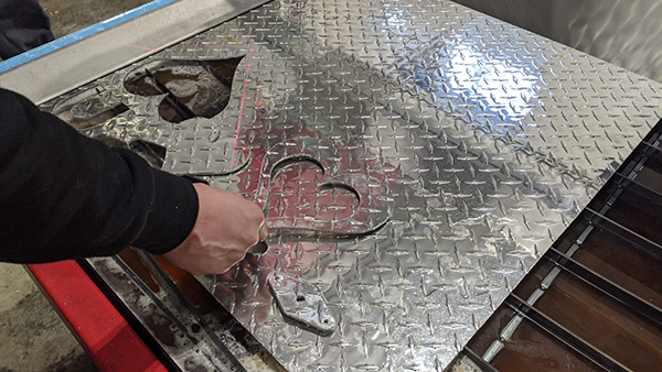 Mark Obannon, un idraulico di Nantucket, sta utilizzando il suo nuovo tavolo da taglio al plasma CNC Swift-Cut Pro per ritagliare una forma da una lamiera