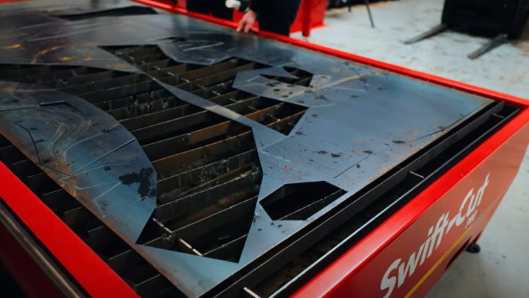 Nate's Forge utilizza il tavolo da taglio al plasma Swift-Cut Pro presso la sala dimostrazioni della sede centrale di Swift-Cut per tagliare i pezzi destinati alla scultura di un gatto alta 3 metri - Foto di una lamiera di acciaio dolce da 3 mm con il pezzo ritagliato.