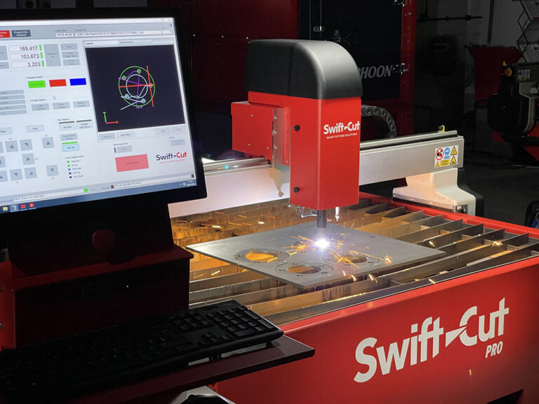 Swift-Cut console showing SwiftCAM software with Swift-Cut Pro CNC plasma metal cutting table using Hypertherm Powermax Sync to cut metal sheet in the background