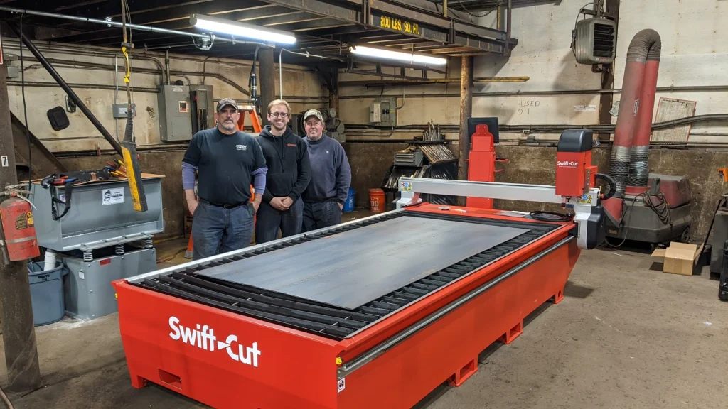 Personal från Stiman Steel står bredvid skärbord till Swift=Cut Pro CNC-plasmaskärare